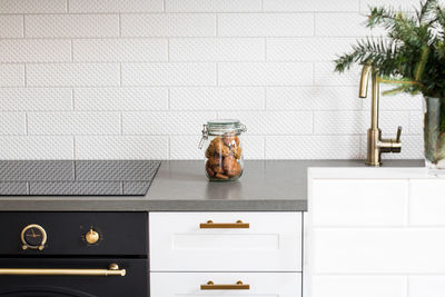 Cookies in glass jar on kitchen counter against wall at home