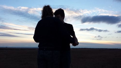 Silhouette of people standing on field