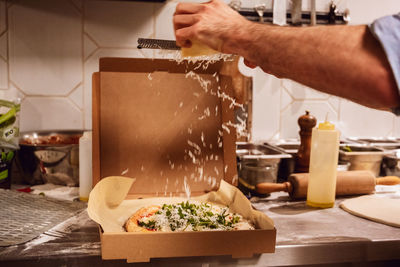 Midsection of person preparing food in kitchen