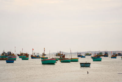 Boats in sea against clear sky