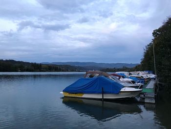 Boat moored in lake against sky