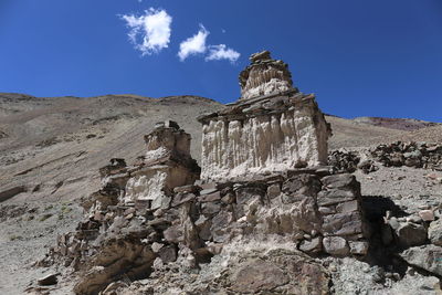 Low angle view of rocks on mountain against sky