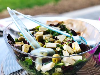 Close-up of salad in bowl with spoons on table