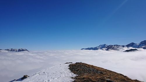 Scenic view of snowcapped mountains against clear blue sky