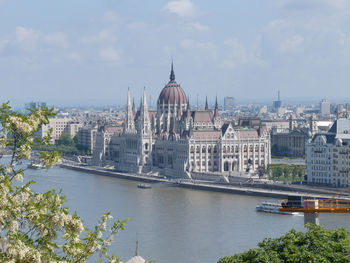 View of cityscape with river against sky