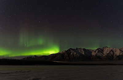 Scenic view of snowcapped mountains against sky at night