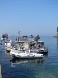 Boats moored on sea against clear sky