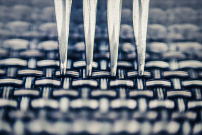 Extreme close-up of metal touching woven pattern