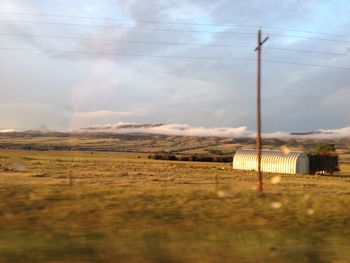 Scenic view of field against cloudy sky