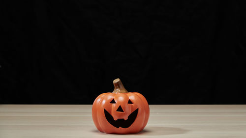 Close-up of pumpkin on table against black background