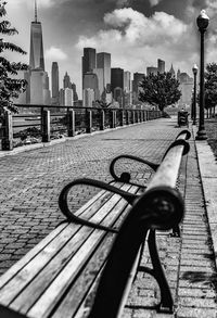 Bicycle parked on railing by street against buildings in city