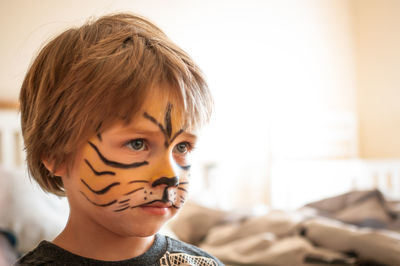 Close-up of boy with face paint looking away