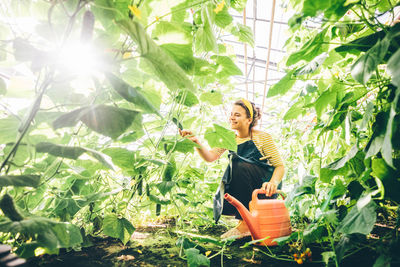 Portrait of woman standing amidst plants