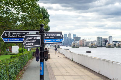 Information sign in city against sky