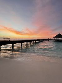 Bridge over sea against sky during sunset