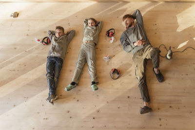 Father and kids have rest, lying after sanding the floor in an eco house. top view, time together