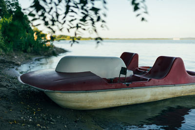 Close-up of boat moored on sea against sky