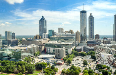 Buildings in city against cloudy sky