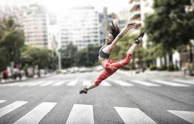 Full length of woman jumping on road