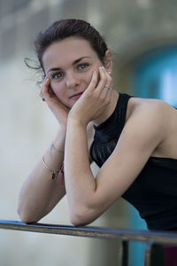 Portrait of young woman leaning on railing