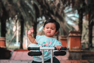 Portrait of girl riding toy scooter at park