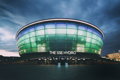 Low angle view of illuminated building against cloudy sky