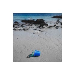 Deck chairs on beach against sky