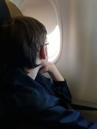 Boy looking through airplane window