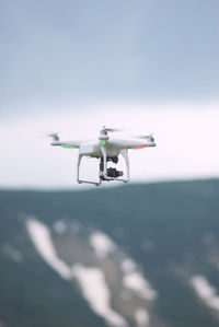 Drone quadcopter flying above a high snowy mountain by getting a geolocation images