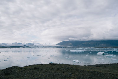 Scenic view of lake against cloudy sky