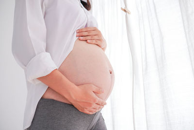 Midsection of woman touching mirror