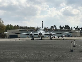 Airplane on airport runway against sky