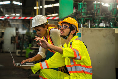 Professional engineers and technicians are inspecting machine operations via a laptop computer.