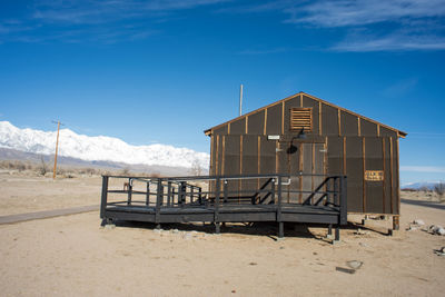 Concentration camp barracks on desert land against blue sky