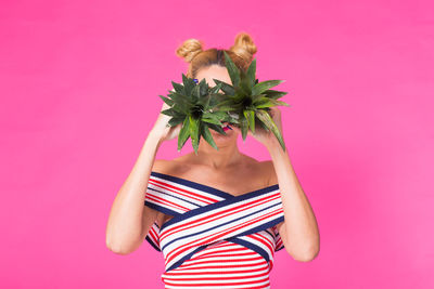 Midsection of woman with sunflower against yellow background