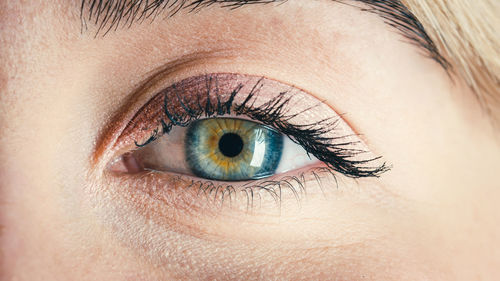 Blue eye of a beautiful model girl that opens slowly