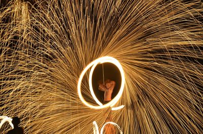 Fire dancer spinning wire wool at night