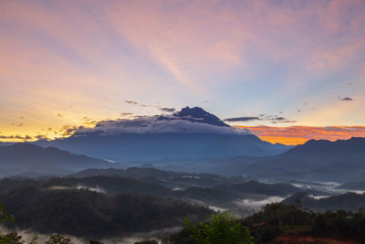 Scenic view of mountains against dramatic sky during sunset