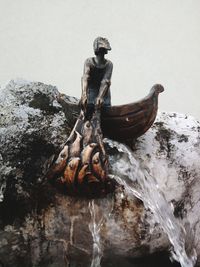 Close-up of old statue against water