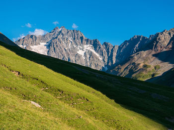 Scenic view of mountains against blue sky