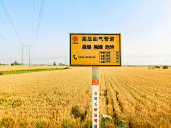 Information sign on field against sky