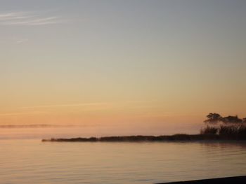 Scenic view of lake against clear sky during sunset