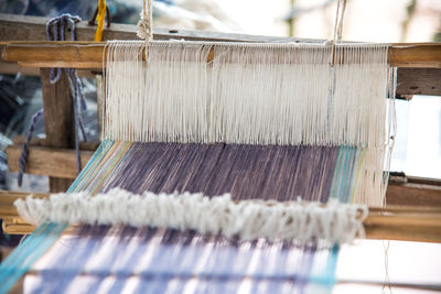 Close-up of thread weaving in loom at factory