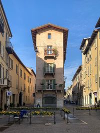 Street amidst buildings against clear blue sky