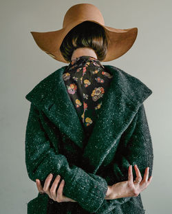 Low section of person wearing hat standing against white background