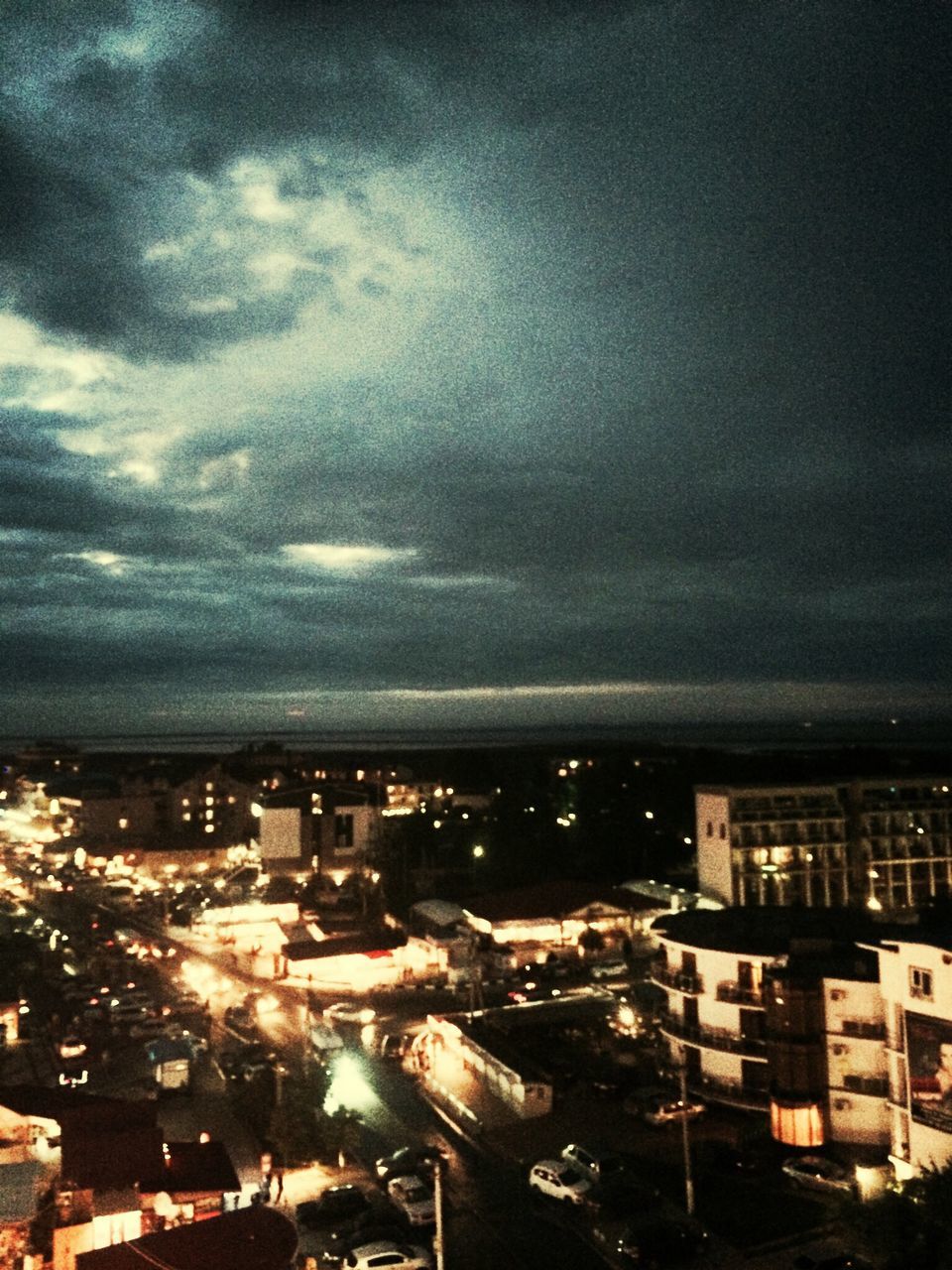 building exterior, city, architecture, cityscape, built structure, sky, cloud - sky, illuminated, crowded, high angle view, residential district, residential building, night, residential structure, cloudy, dusk, water, city life, cloud, outdoors