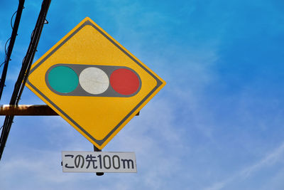 Low angle view of traffic sign against blue sky