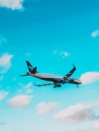 Low angle view of airplane against blue sky