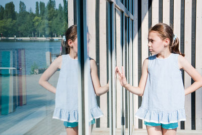 Girl standing by window