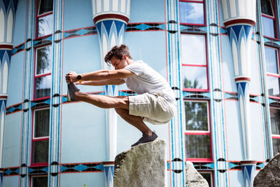 Young man exercising on stone